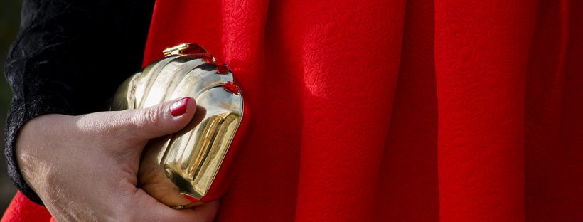 Look navideño vestido rojo, detalle tela y bolso dorado